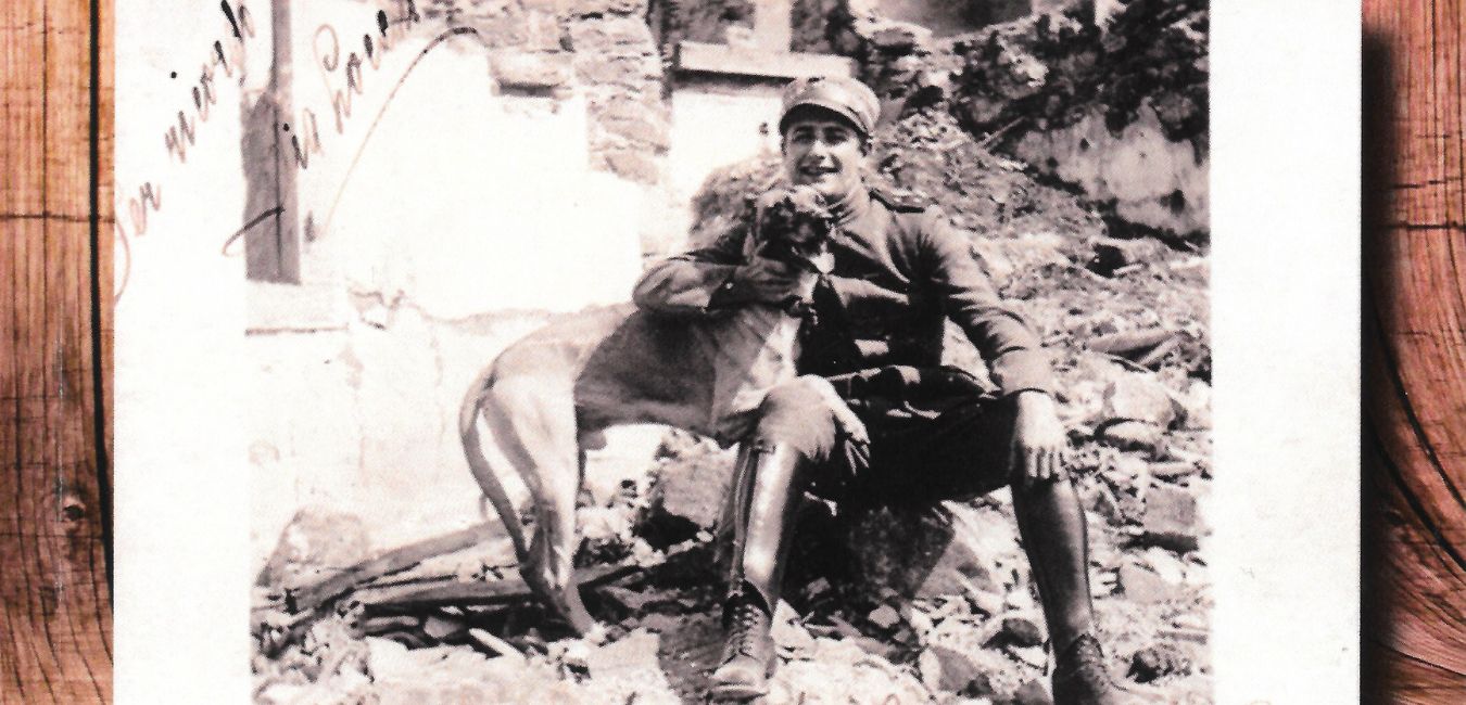 Vittorio Locchi in una cartolina d'epoca, seduto sulle macerie all'ingresso di Gorizia appena conquistata insieme al suo inseparabile cane Isonzo